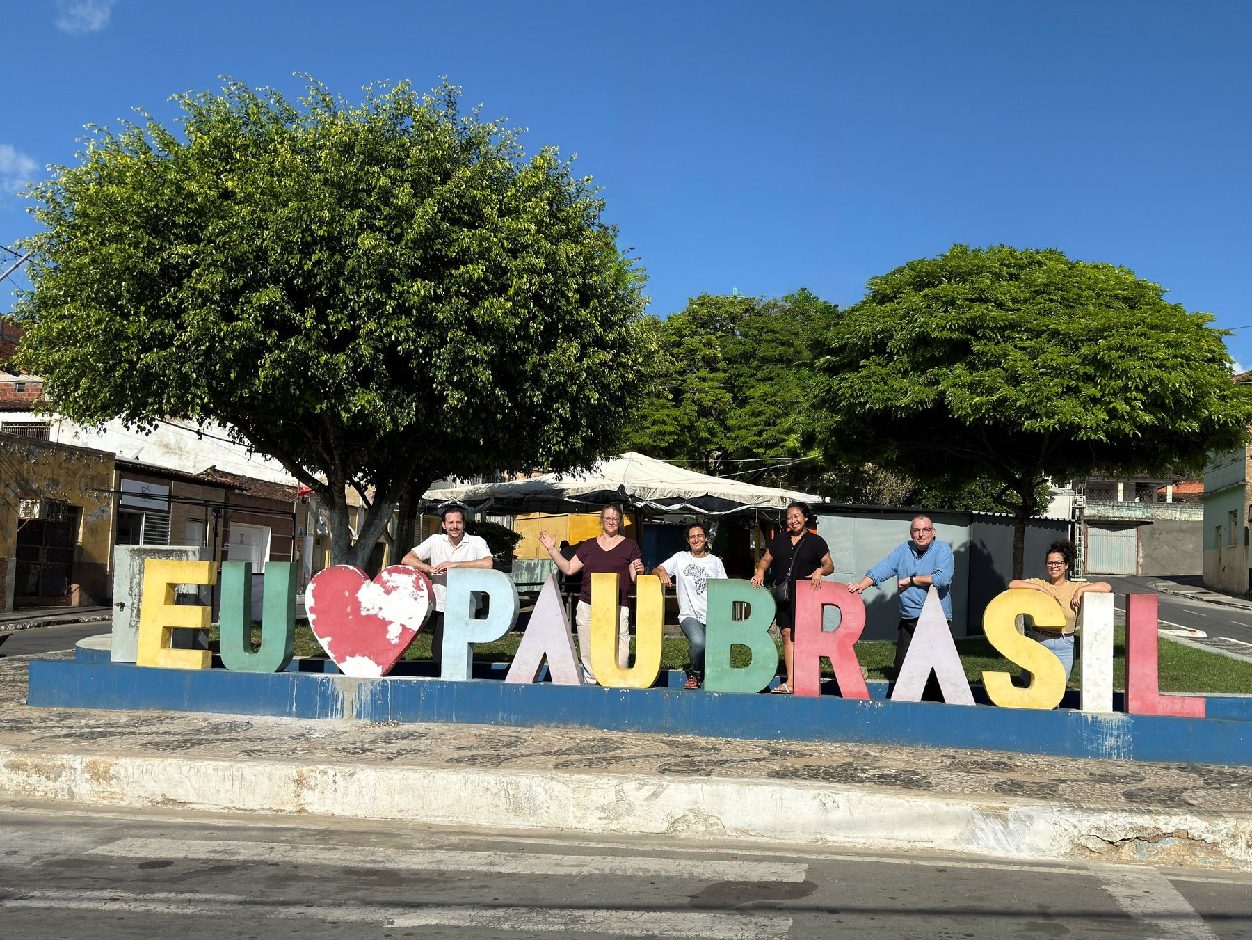 Gruppe vor dem Schriftzug Eu amo Pau Brasil.